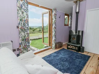 a living room with a couch and a fireplace at Brondel Luxury Shepherd's Hut in Aberystwyth