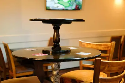 a table with a black top on a table with chairs at The Castle Inn in Wigmore