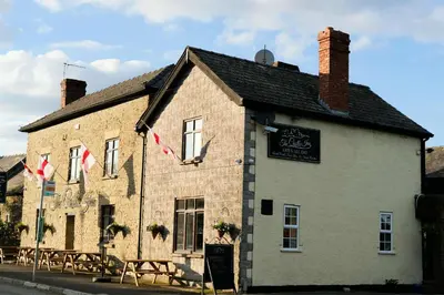 a building with tables and chairs in front of it at The Castle Inn in Wigmore