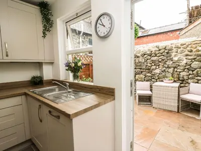 a kitchen with a sink and a clock on a wall at 6 Upperfield Street in Dolgellau