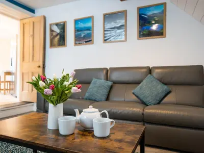 a living room with a couch and a table with flowers at Garn View in Dolgellau