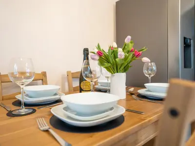 a table with plates and glasses and a bottle of wine at Garn View in Dolgellau