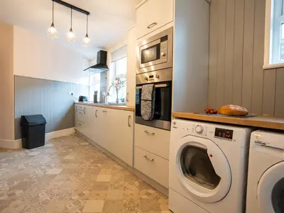 a kitchen with a washing machine and a microwave at Garn View in Dolgellau