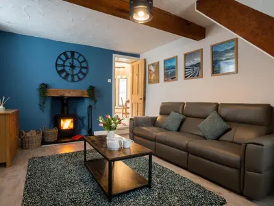 a living room with a couch and a fireplace at Garn View in Dolgellau