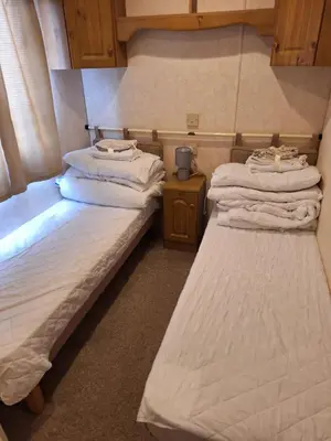 two twin beds in a room with a small table at TF1 Static in Aberystwyth