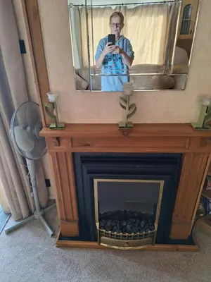 a woman taking a picture of a fireplace with a mirror at TF1 Static in Aberystwyth
