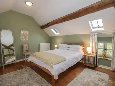 a bedroom with a large bed and a window at Malt House in Bishops Castle