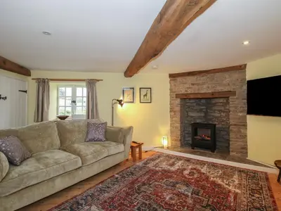 a living room with a couch and a fireplace at Malt House in Bishops Castle