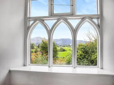 an open window with a view of the countryside at Cynfal Fawr Farmhouse in Ffestiniog