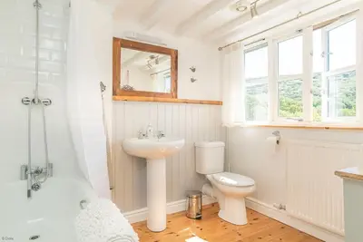 a bathroom with a sink and a toilet and a mirror at Artro in Llanbedr