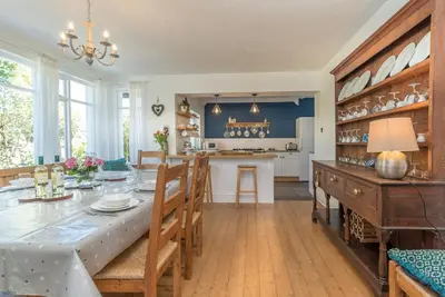 a dining room and kitchen with a table and chairs at Artro in Llanbedr