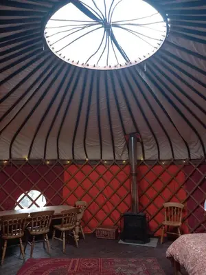 a room with a table and chairs in a yurt at Hillside Retreats in Machynlleth