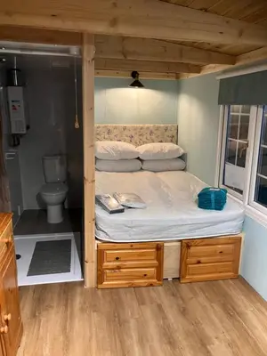 a bed in a small room with a toilet at The Rheidol Shepherds Hut in Aberystwyth