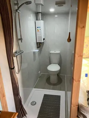 a small bathroom with a toilet and a shower at The Rheidol Shepherds Hut in Aberystwyth