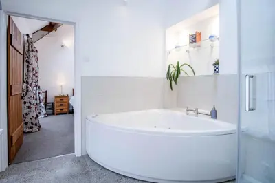 a bathroom with a large white tub in a room at West Barn - 2 Bedroom Cottage - Llandeilo in Llandeilo