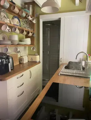 a kitchen with white cabinets and a sink in it at Patchwork cottage - Grade 2 listed cottage in Snowdonia in Maentwrog