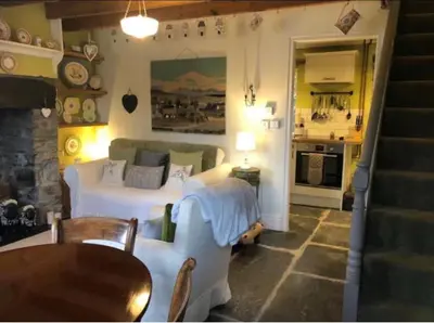 a living room with a bed and a kitchen at Patchwork cottage - Grade 2 listed cottage in Snowdonia in Maentwrog