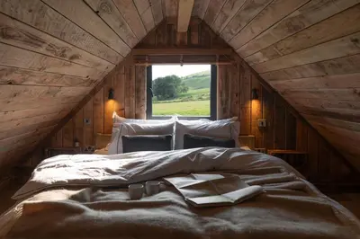 a large bed in a room with a window at Woolly Wood Cabins - Nant in Abbey-Cwmhir
