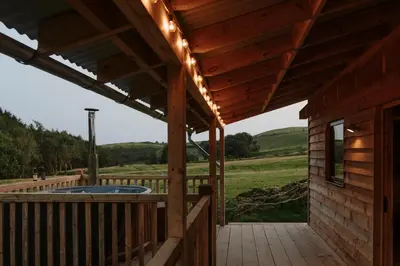 a large deck with a hot tub on a house at Woolly Wood Cabins - Nant in Abbey-Cwmhir