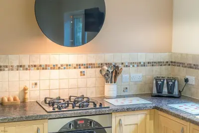 a kitchen with a stove and a mirror on the wall at Mehefin in Harlech