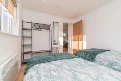 a bedroom with two beds and a mirror at Y-Berllan in Dyffryn