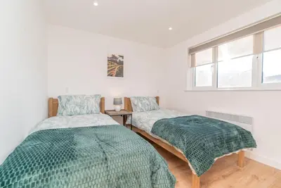 a bedroom with two beds and a window at Y-Berllan in Dyffryn