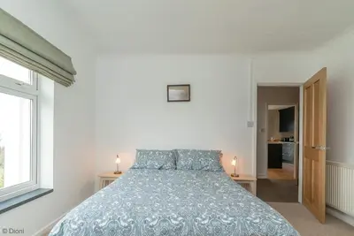 a bedroom with a bed with a blue comforter at Bryn-Yr-Aur in Llanfair