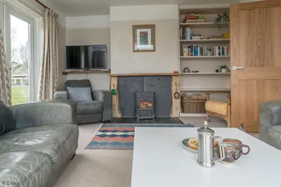 a living room with a couch and a fireplace at Bryn-Yr-Aur in Llanfair