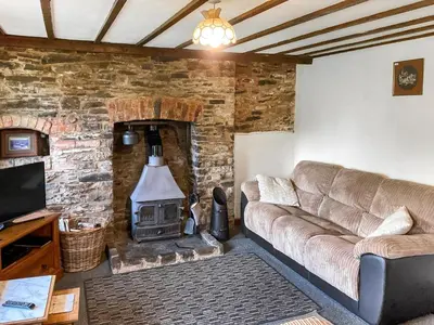 a living room with a couch and a wood stove at Lower Rheol in Erwood