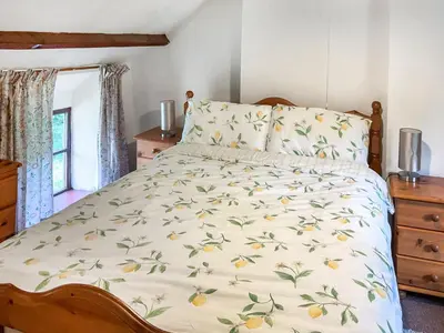 a bedroom with a bed with a yellow and green comforter at Lower Rheol in Erwood