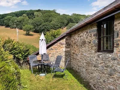 a table and chairs sitting outside of a stone building at Lower Rheol in Erwood