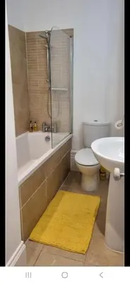 a bathroom with a tub and a toilet and a sink at Seaview Apartment in Aberystwyth