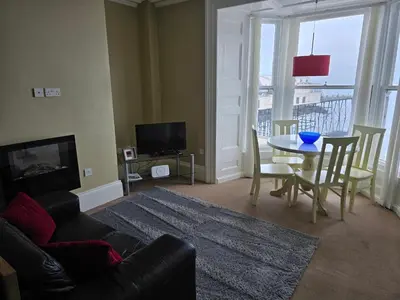 a living room with a couch and a table and a television at Seaview Apartment in Aberystwyth