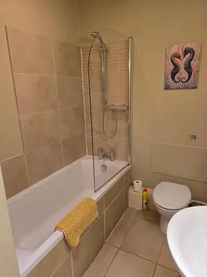 a bathroom with a tub and a toilet and a sink at Seaview Apartment in Aberystwyth
