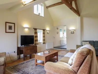 a living room with a couch and a tv at Upper Pandy Farm in Welshpool