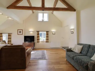 a living room with a couch and a tv at Upper Pandy Farm in Welshpool