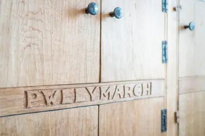 a wooden door with the word pharmacyyard written on it at Pwll-Y-March in Llanbedr