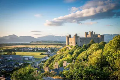 a castle on top of a hill with a town at Pwll-Y-March in Llanbedr
