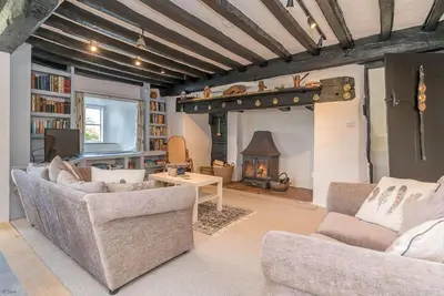 a living room with two couches and a fireplace at Pwll-Y-March in Llanbedr