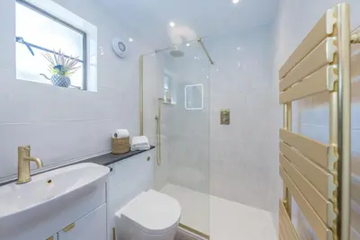 a white bathroom with a toilet and a sink at Sarn-Badrig in Harlech