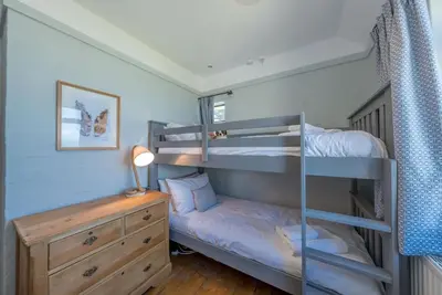 a bedroom with two bunk beds and a desk at Sarn-Badrig in Harlech