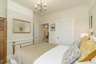 a bedroom with a bed and a mirror and a chandelier at Rheithordy in Blaenau-Ffestiniog