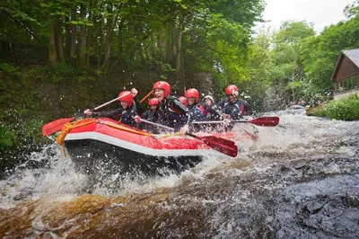 a group of people in a raft in a river at Rheithordy in Blaenau-Ffestiniog