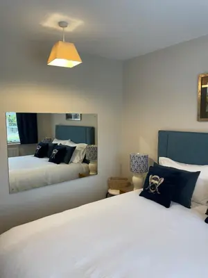 a bedroom with two beds and a large mirror at Vicarage Court detached bungalow in Oswestry