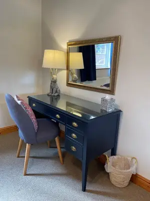 a blue desk with a chair and a mirror at Vicarage Court detached bungalow in Oswestry