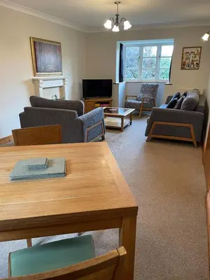 a living room with couches and a table at Vicarage Court detached bungalow in Oswestry