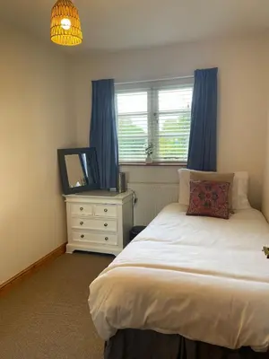 a bedroom with a bed and a dresser and a window at Vicarage Court detached bungalow in Oswestry