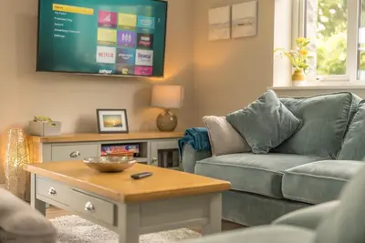 a living room with a couch and a tv at Tan-Y-Foel in Dyffryn