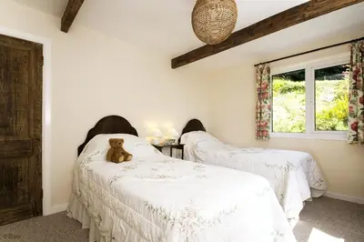 two beds in a room with a teddy bear sitting on them at Hen-Feudy in Dyffryn