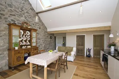 a kitchen and dining room with a stone wall at Hen-Feudy in Dyffryn